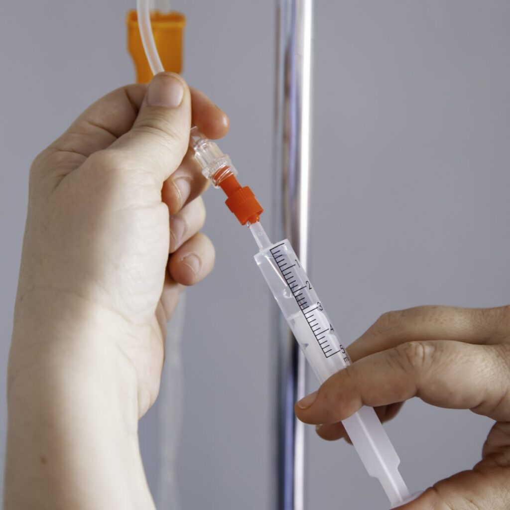 Person administering meds through IV.