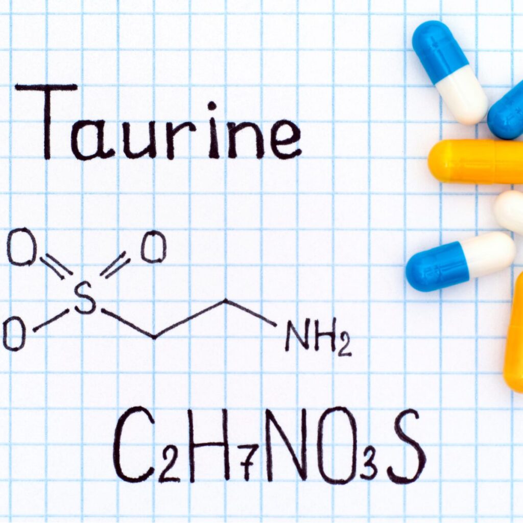 Chemical formula of taurine on paper with some pills.