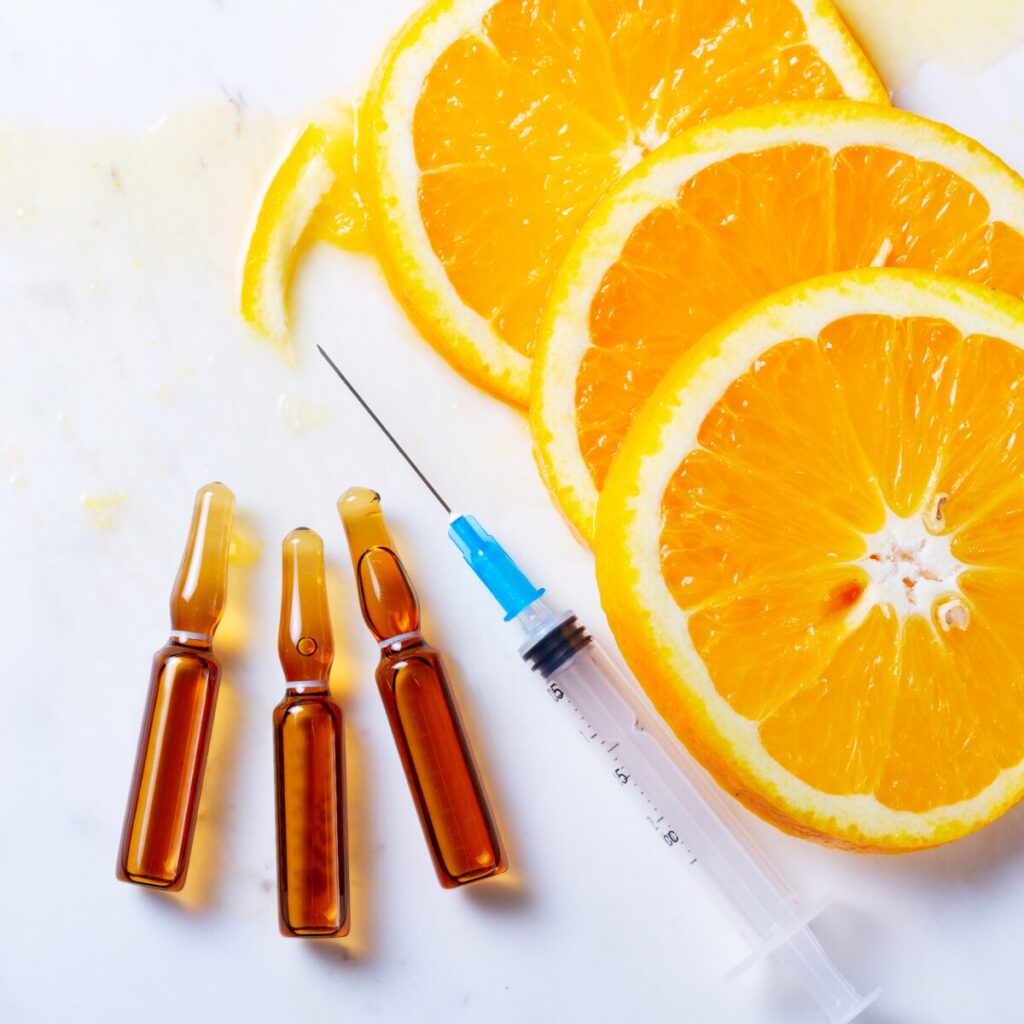 Slices of orange alongside injection and vials.