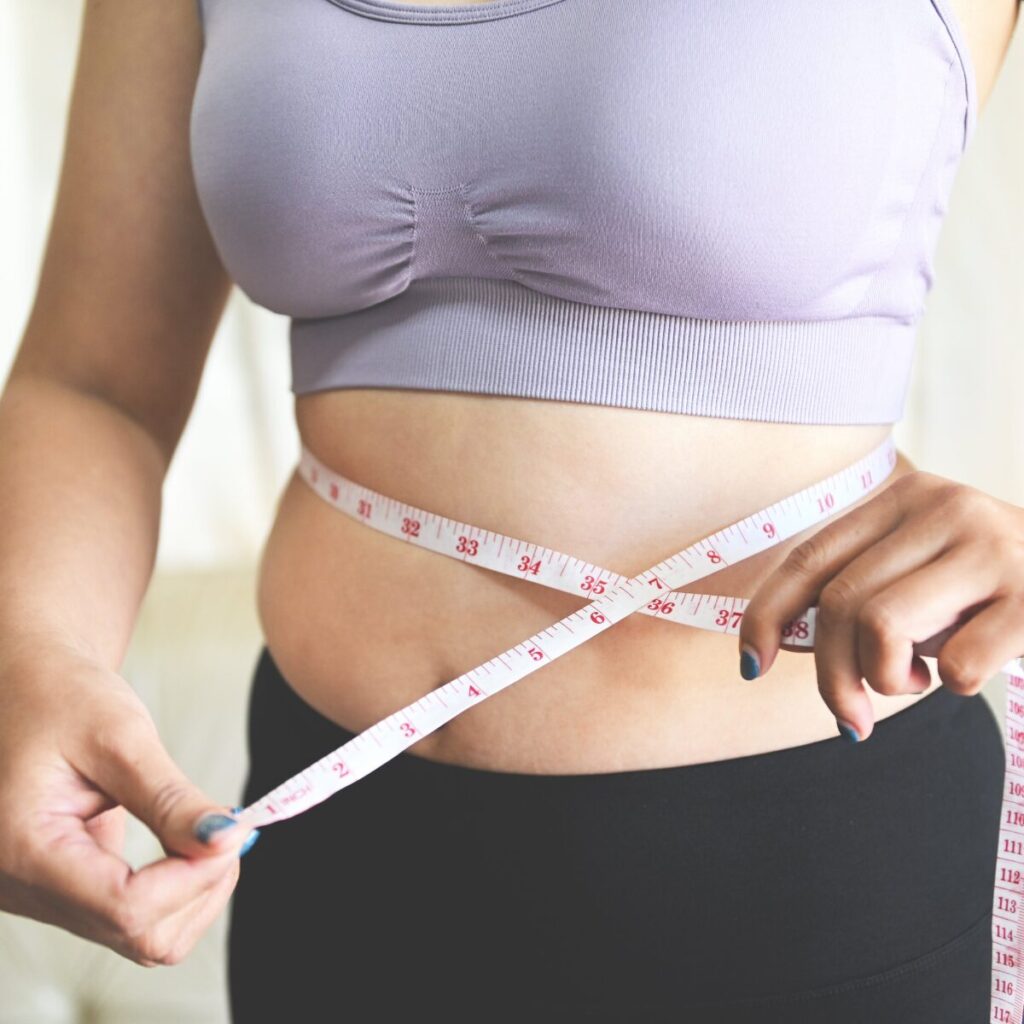 Woman measuring her waist.