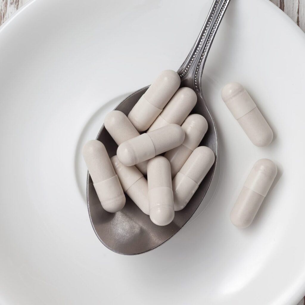 Glutathione pills on a spoon.