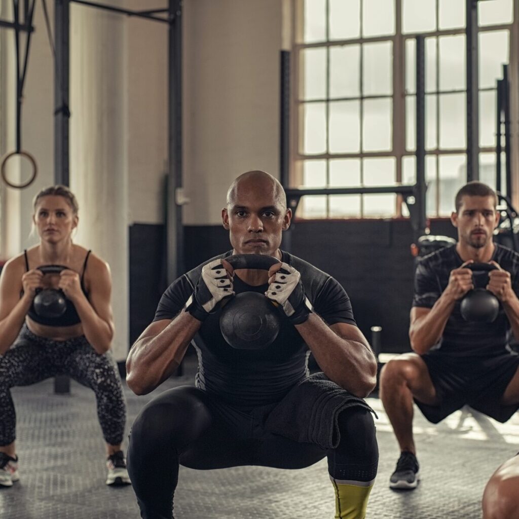 Group doing kettlebell squat during Crossfit training.