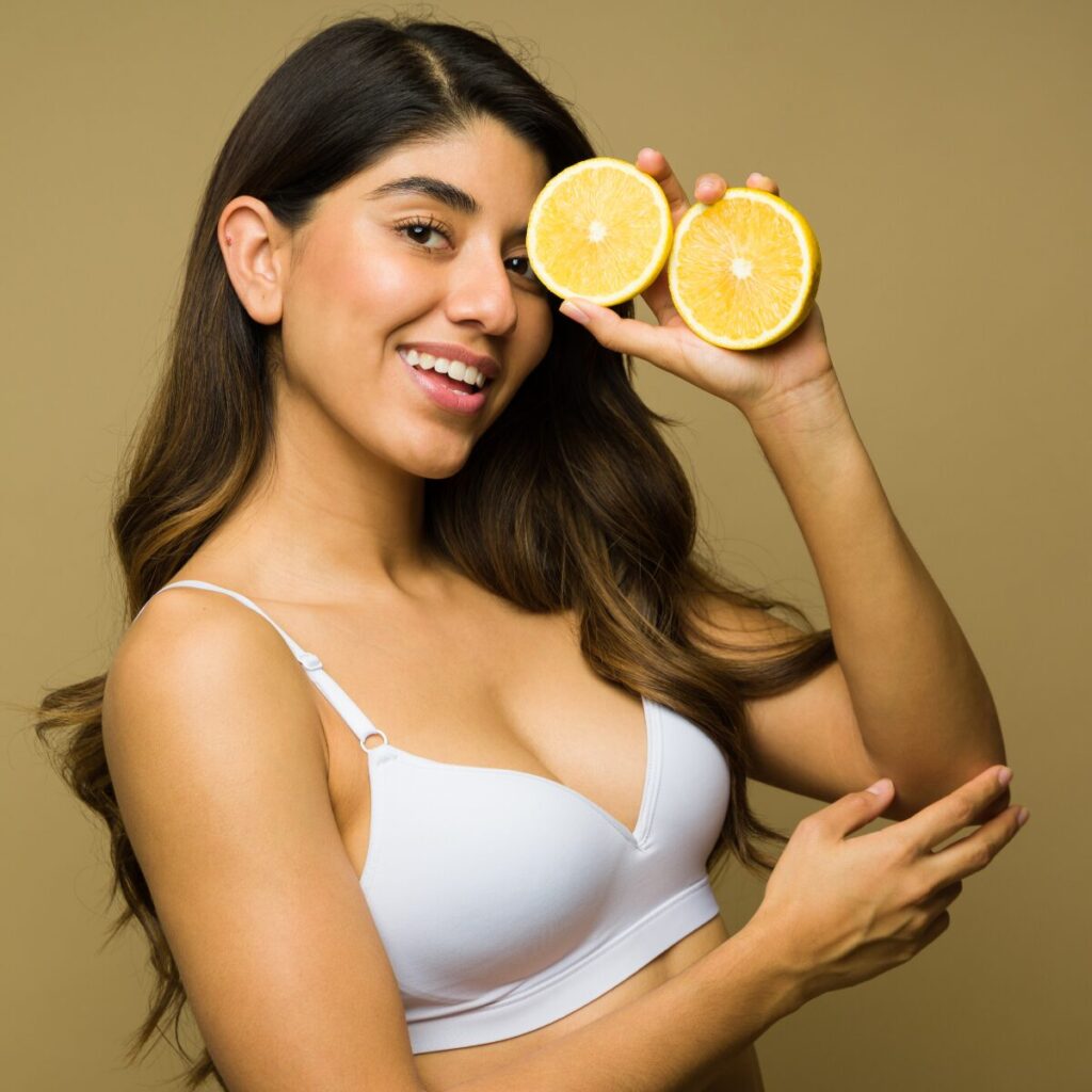 Woman holding citrus fruits.