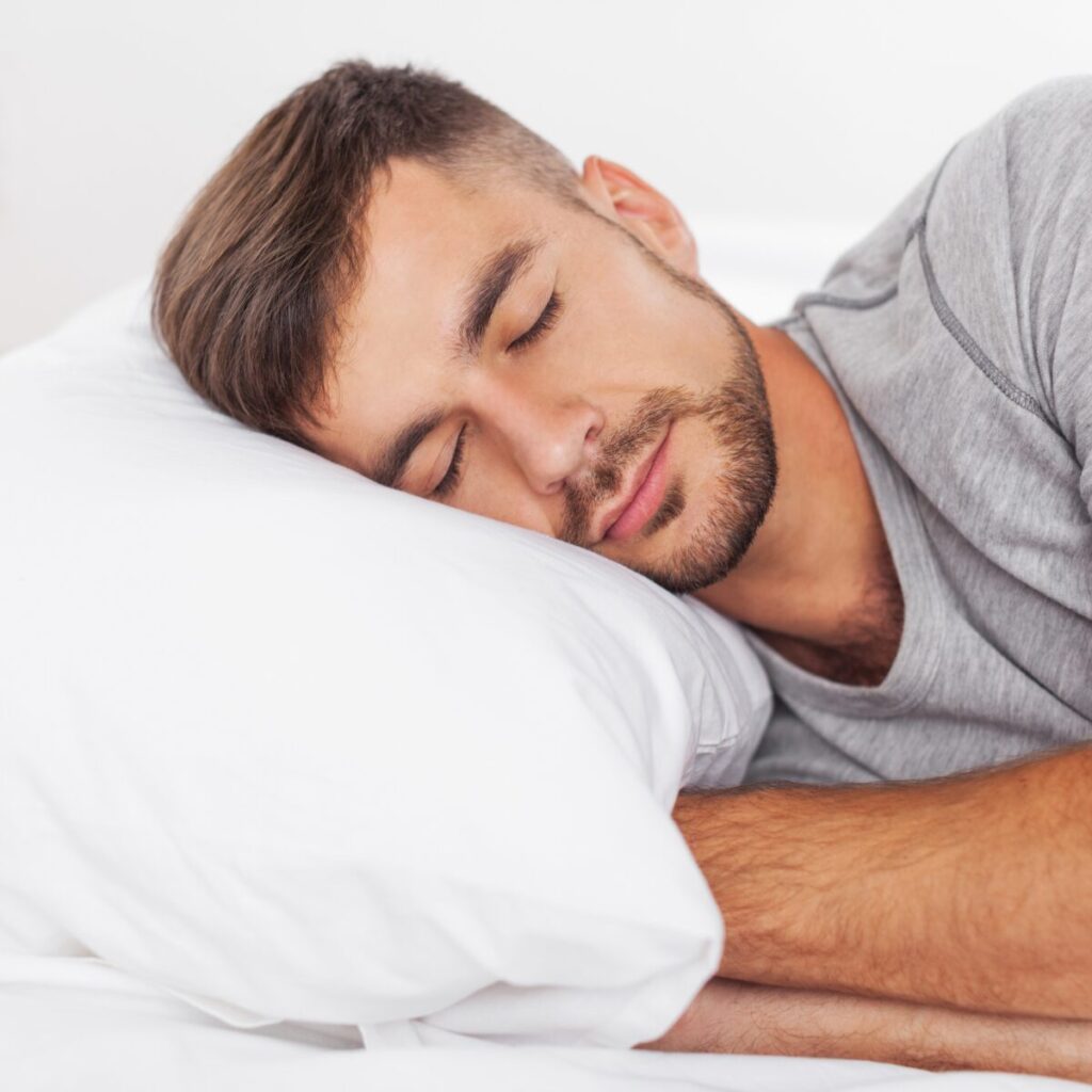 Close up of a man sleeping on his bed.