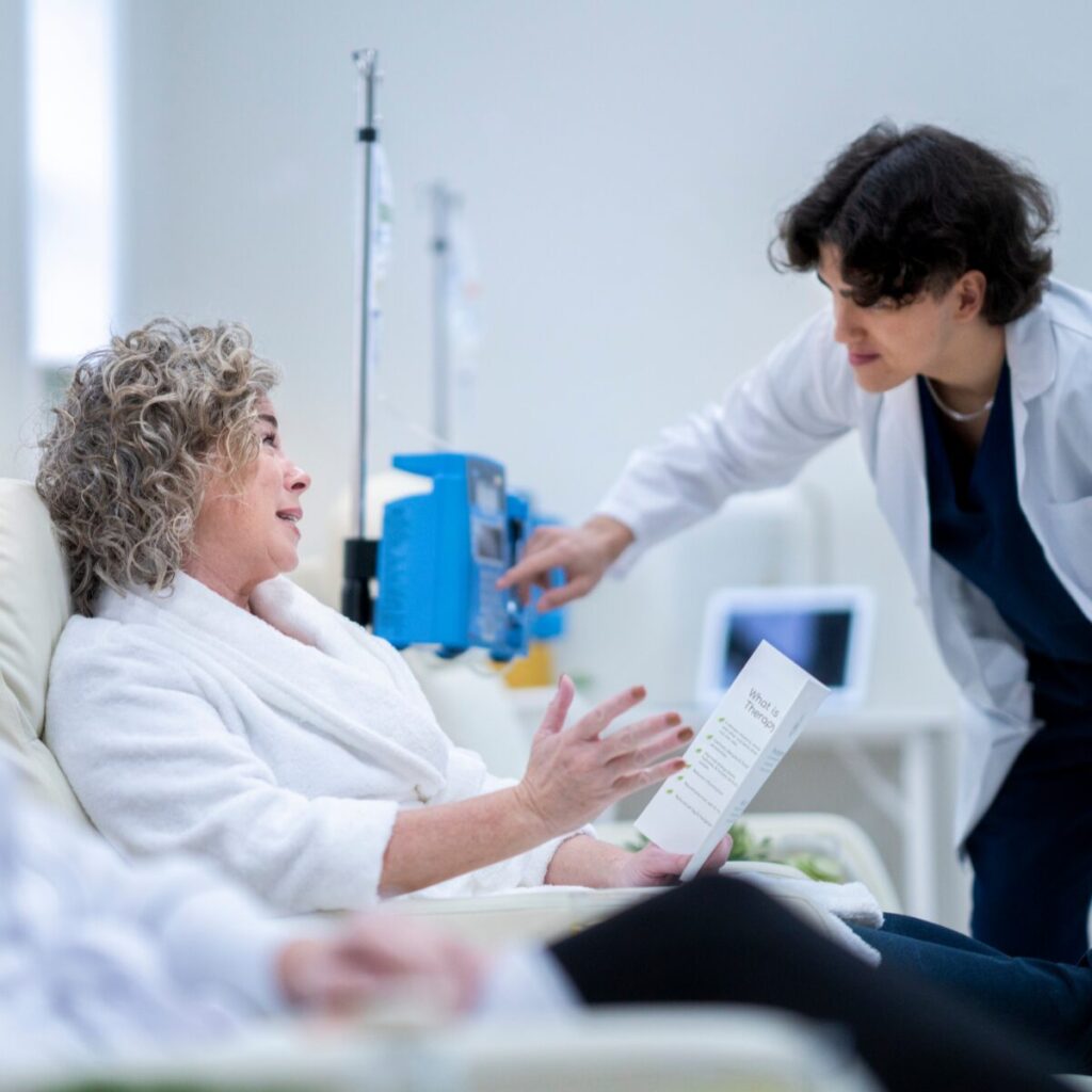 Medical professional checking on IV therapy patient.