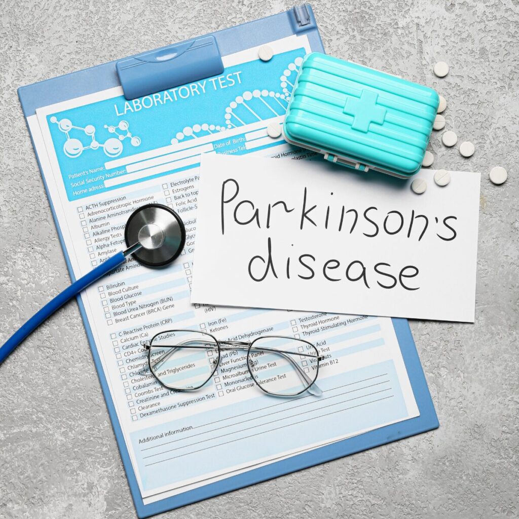 Paper with "Parkinson's disease' written on it, alongside pills, laboratory test document, and stethoscope.