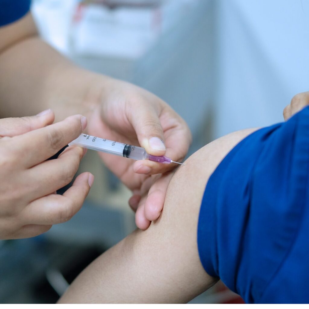 Arm being injected by nurse.