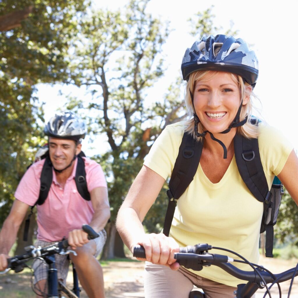Middle aged couple riding a bike.