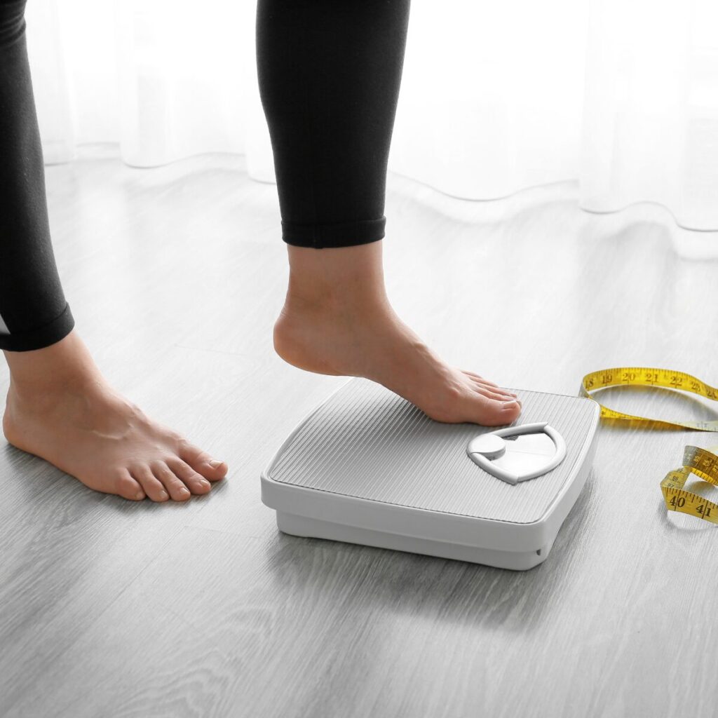 Person stepping on a weighing scale.