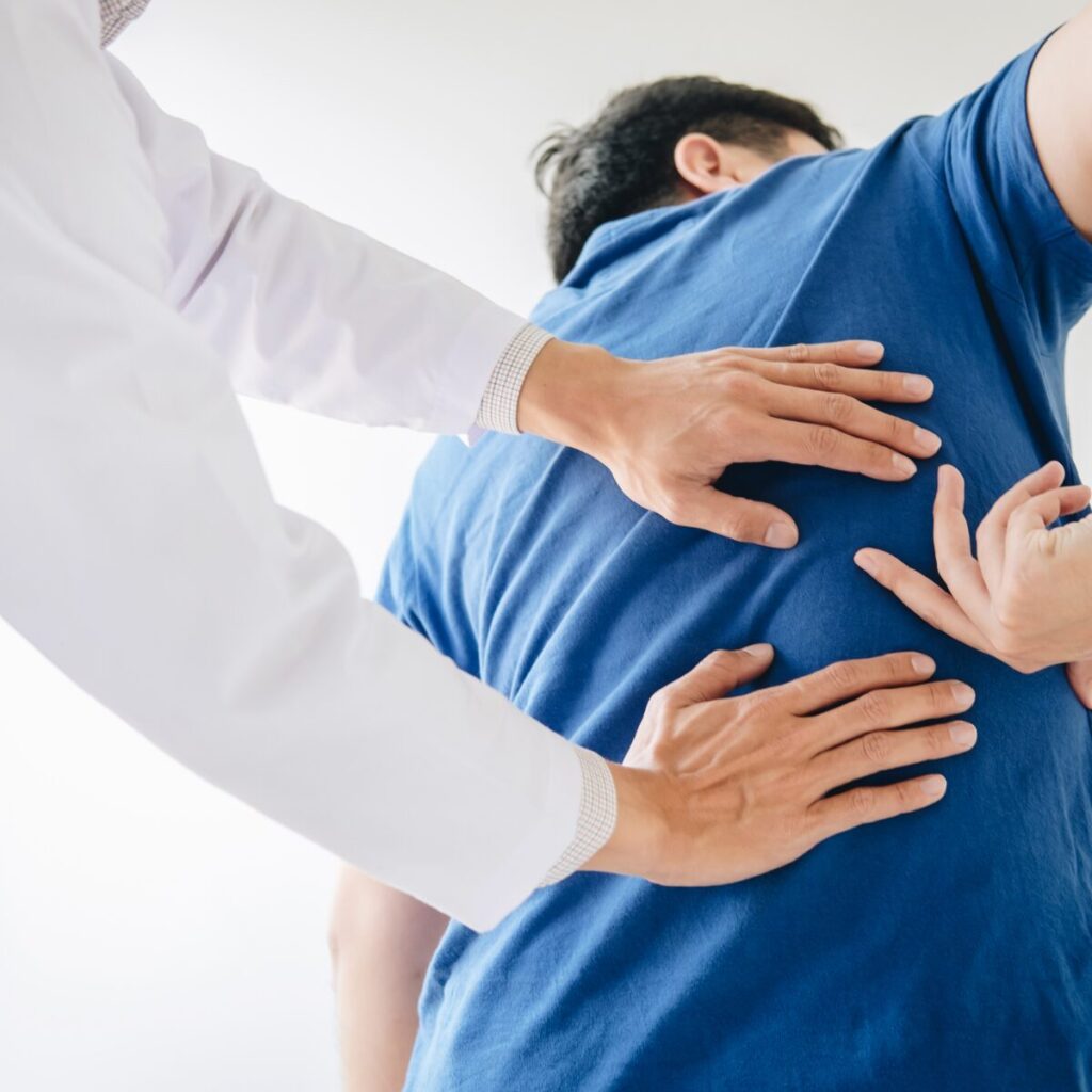 Doctor checking up man's back.